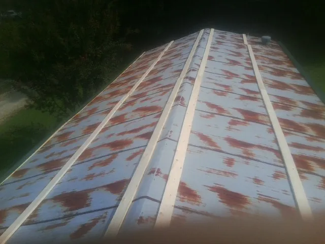 Rusted metal roof panels with new wood purlins before replacement — Storm Damage Roof Repair in Marthasville by Roofing Brothers