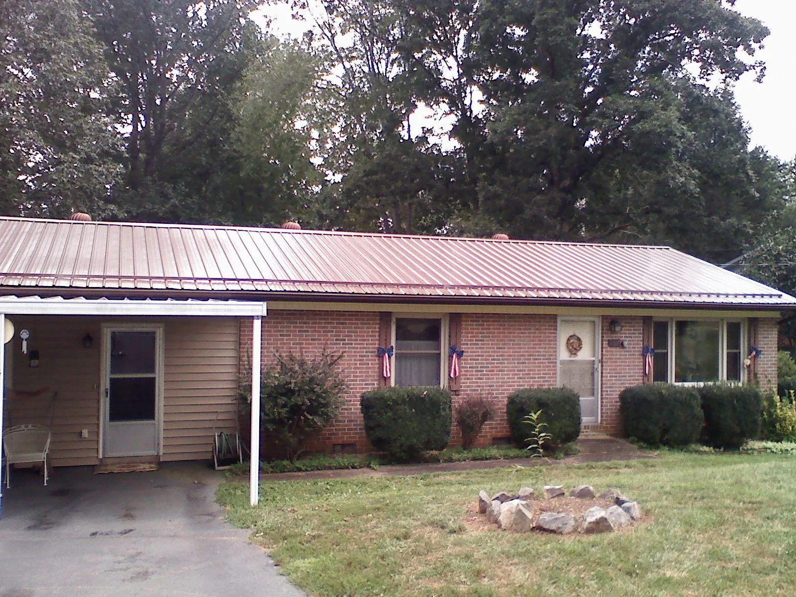 Bronze metal roof and carport on a brick ranch home — Roof Repair work by our crew in Marthasville